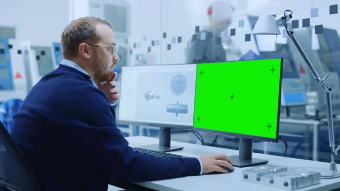 在个人计算机上工作的男工程师，两个监视器屏幕显示色度键/绿屏显示和带有工业机械机构3D模型的cad软