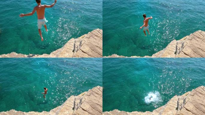 慢动作: 无忧无虑的人从岩石悬崖上潜入深蓝色的大海。