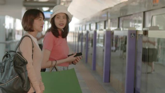 两名女游客在火车站站台等车时交谈，来自RAW VDO的4k慢镜头