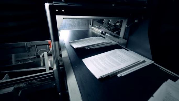 白纸在印刷输送机上移动，自动化机器。