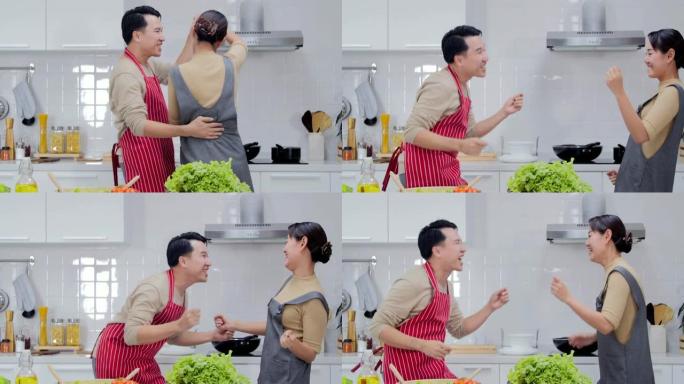 美丽的夫妇在厨房一起做饭时跳舞和微笑。日本家庭