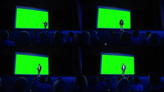 在舞台上，主旨演讲者向观众展示了新产品，在他身后的电影院里，绿屏，模型，色键。业务现场活动或设备显示