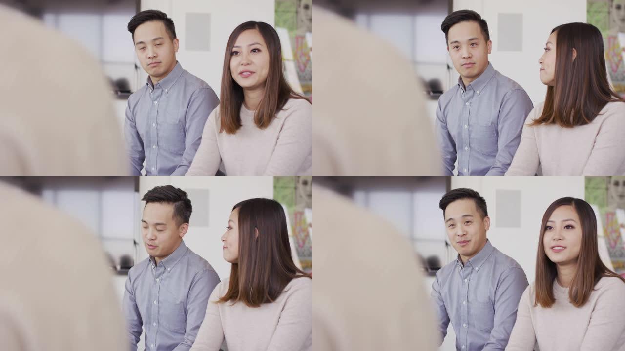 年轻的亚洲夫妇与治疗师交谈