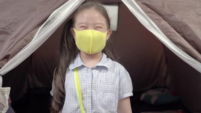 亚洲小女孩在新型冠状病毒肺炎电晕病毒大流行期间用黑色防护面罩微笑