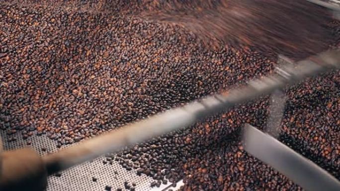 在工厂的工作机中烘烤的棕色咖啡豆。