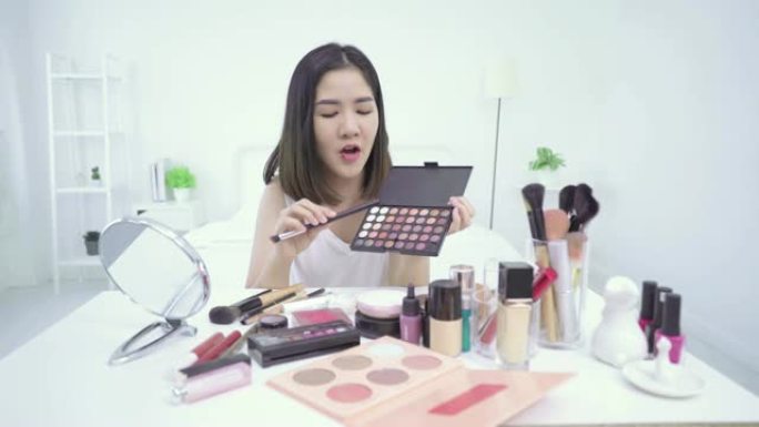 4k分辨率亚洲女性美容博主或v-logger在嘴上涂口红做化妆教程