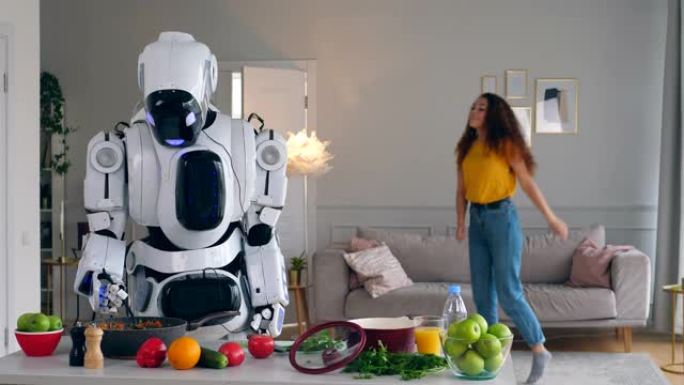 半机械人与人类概念。一个机器人烹饪食物，而一个女人跳舞。