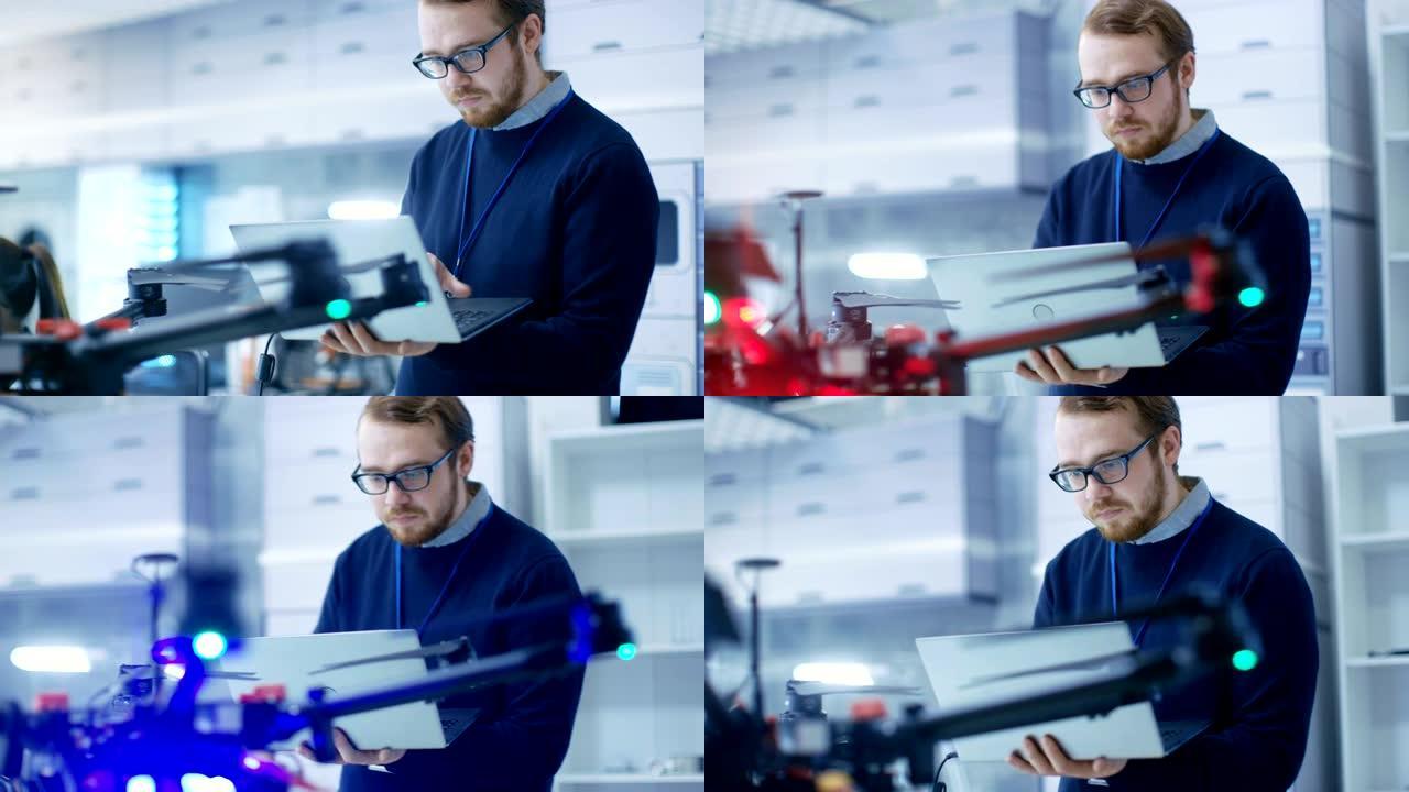 男性工程师在手拿笔记本电脑时对无人机进行编程。他在一个明亮的现代高科技实验室工作。