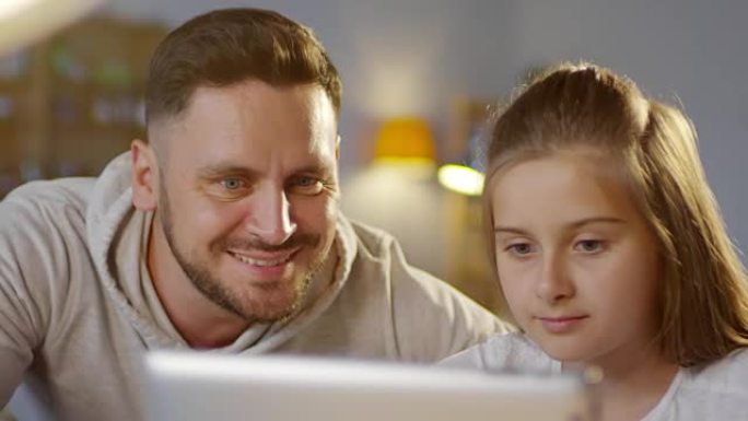 父亲和女儿一起使用数字平板电脑