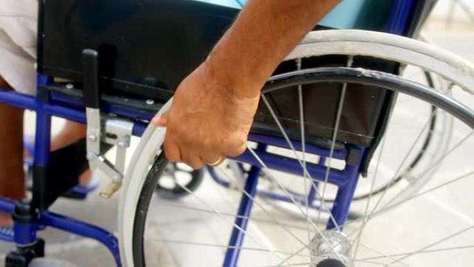 残障活跃的非裔美国人老年人在promenade 4k上移动轮椅的特写镜头