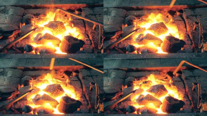 人在锻造炉中移动加热煤。