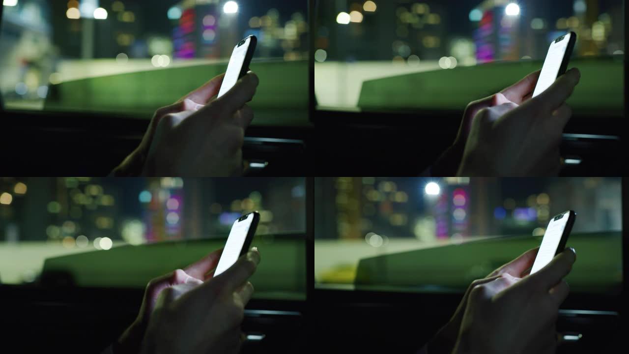 慢动作近距离的商人的手使用手机在一个现代汽车旅行与司机在市中心的夜晚。