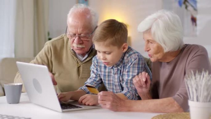 男孩和祖父母一起在网上购物