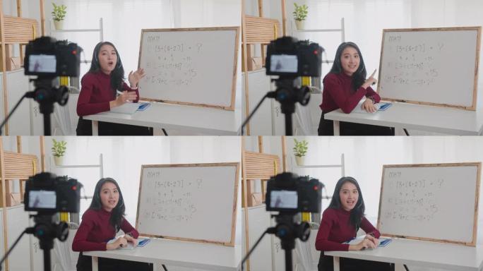 美丽的亚洲女性在线教授数学，微笑的亚洲女性老师在线录制vlog或数学课。