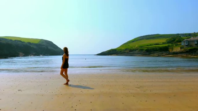 女人在微风中走在海滩上4k