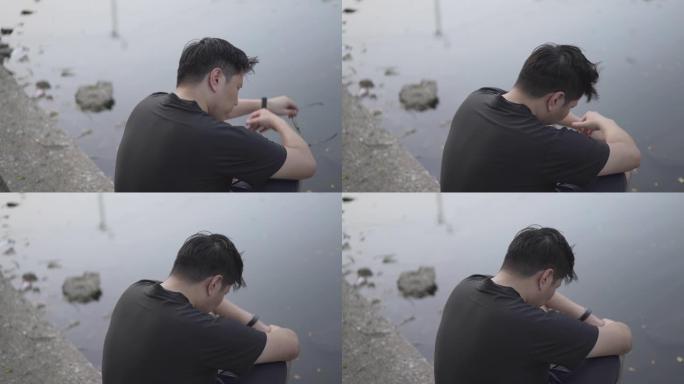 无望的人坐在河边哭泣的男人