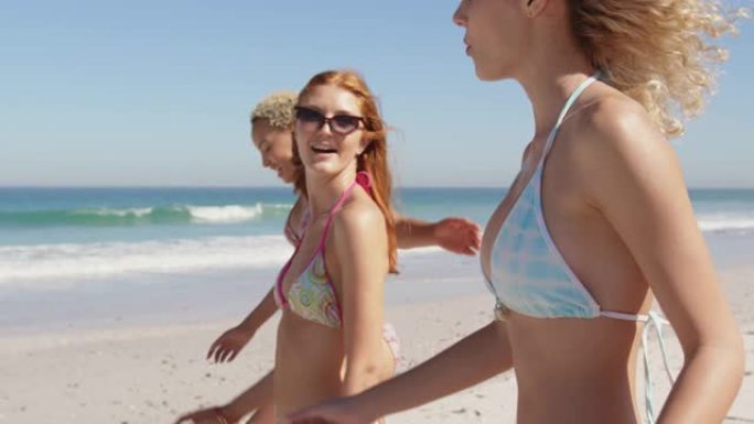 年轻的成年女性朋友在海滩上散步4k
