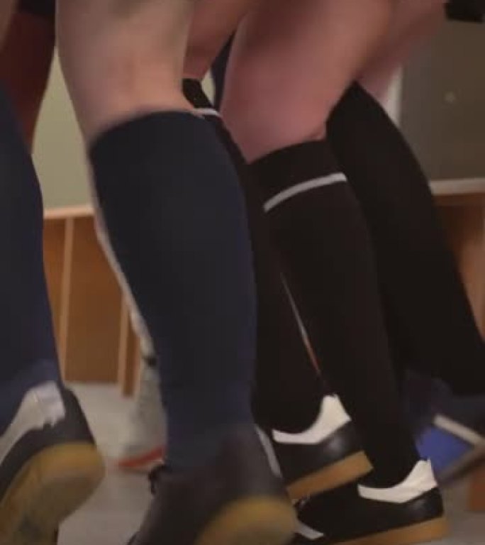 女子足球队的腿挤在更衣室里