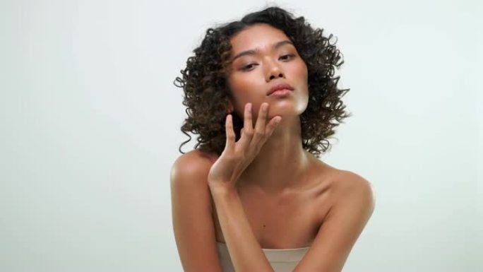 非洲妇女用美容护肤产品在白色背景上摩擦皮肤。