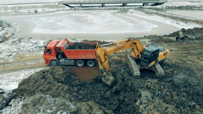 工业拖拉机在采石场用沙子装载卡车。新建筑工地。建筑工地的重型机械。