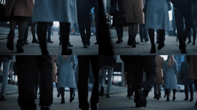 一个商务人士步行通勤到办公室的特写镜头。经理和商人走在拥挤的步行街上。市中心阴天。