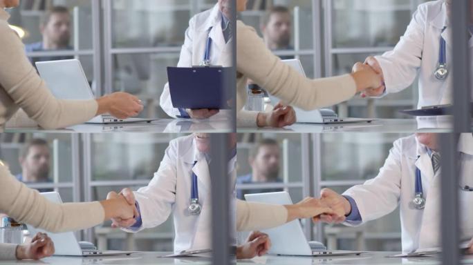 女人给文件并与医生握手