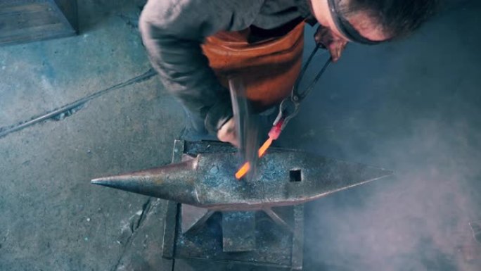 铁匠正在铁砧上锤击金属工具