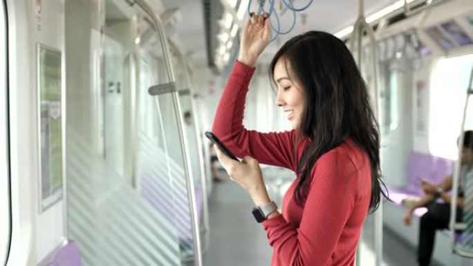 在地铁中使用智能手机的亚洲女性