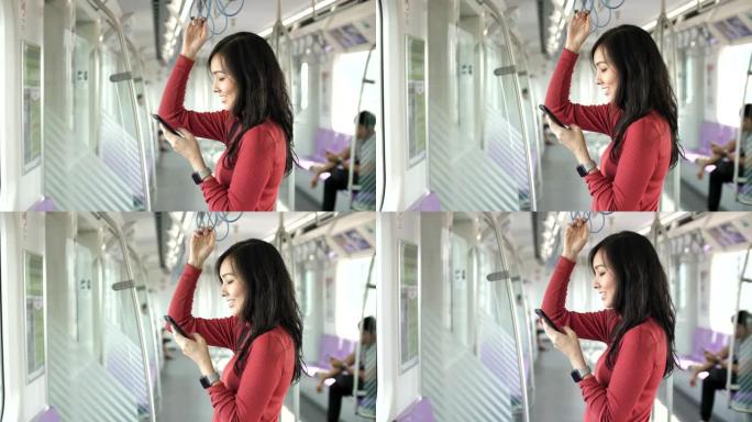 在地铁中使用智能手机的亚洲女性