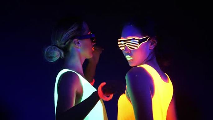 性感cyber raver女人在UV黑光下在荧光服装拍摄的梦幻视频。两个性感cyber glow r
