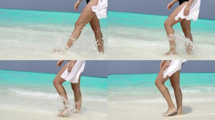 女士女士在马尔代夫阳光明媚的热带海洋冲浪中涉水