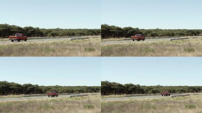 在阿根廷的乡间小路上行驶的红色皮卡。