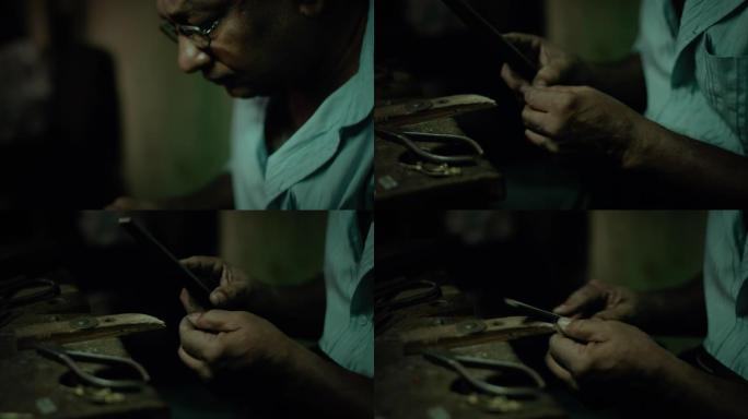 正宗的手工珠宝大师在他的车间里用锉刀/刨丝器做最后的笔触，制作一种新的原创产品。
