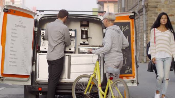 移动咖啡货车卖家为骑自行车的女士提供浓缩咖啡
