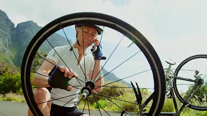 高级自行车手在手机上说话时修理自行车4k