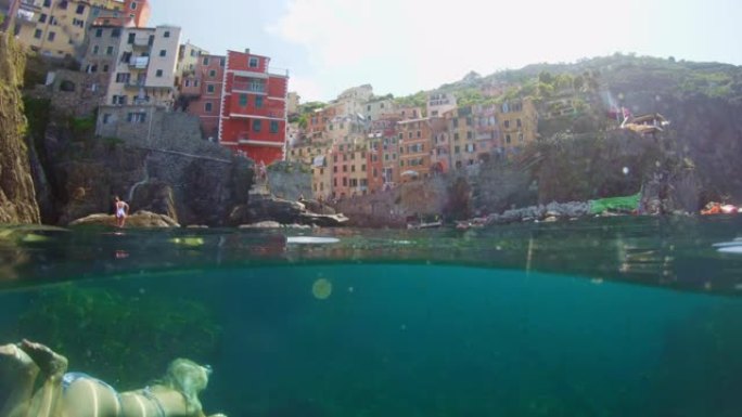 年轻女子女士在意大利五渔村的水下游泳
