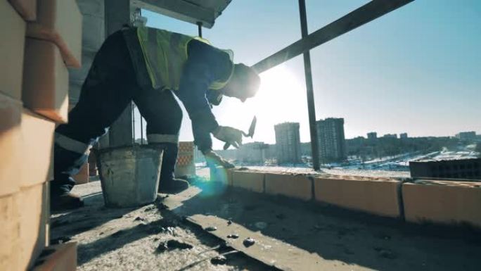 男性建造者正在进行中的建筑中进行砌筑