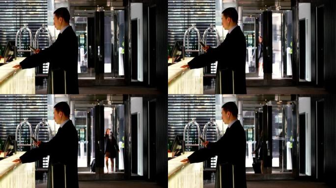 亚洲商人在现代酒店4k接待处使用手机的侧视图