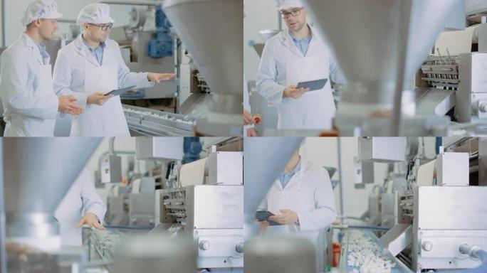 两名年轻的男性质量主管或食品技术人员正在饺子食品工厂检查自动化生产。员工使用平板电脑工作。他们穿着白