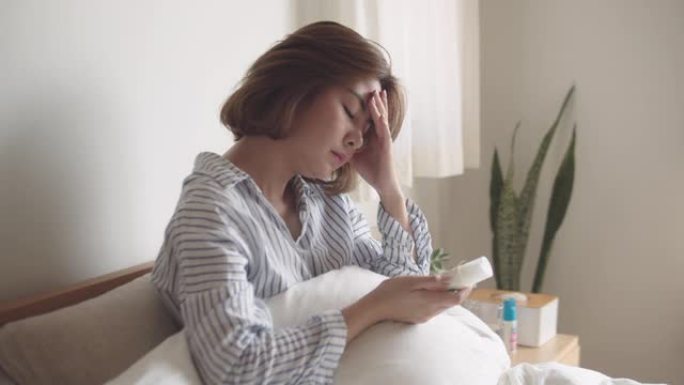 年轻女子拿着止痛药药瓶阅读处方