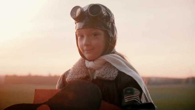 小女孩穿着有趣的飞机飞行员服装微笑着用害羞平静的眼睛慢动作拍摄的惊人肖像。