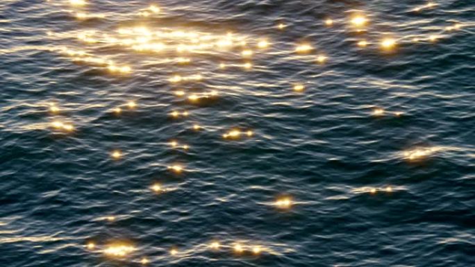 黑暗的海面在缓慢地挥舞着。阳光在水面上反射，闪烁着金色的光彩。4K
