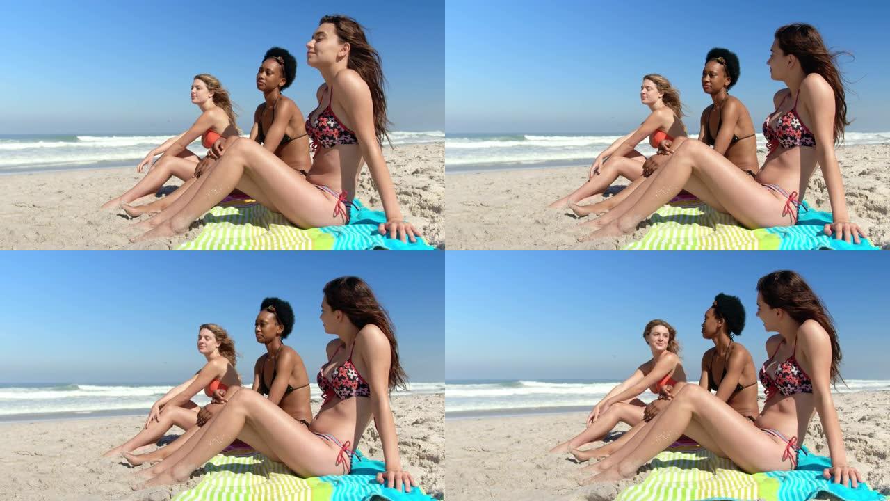年轻的女性朋友一起坐在4k海滩上