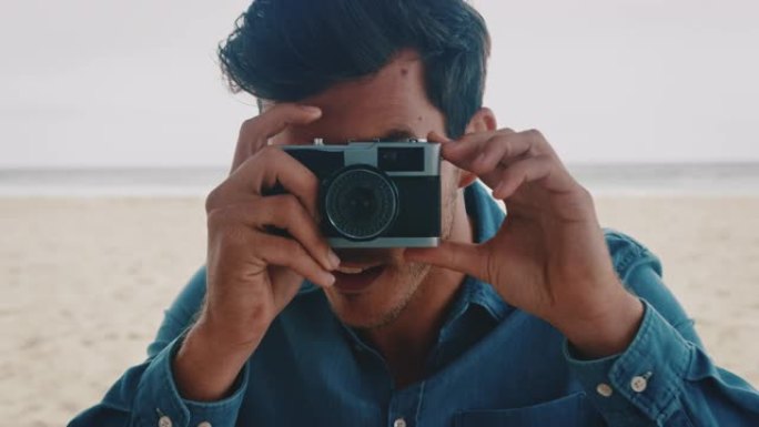 年轻人在海滩上通过相机拍照