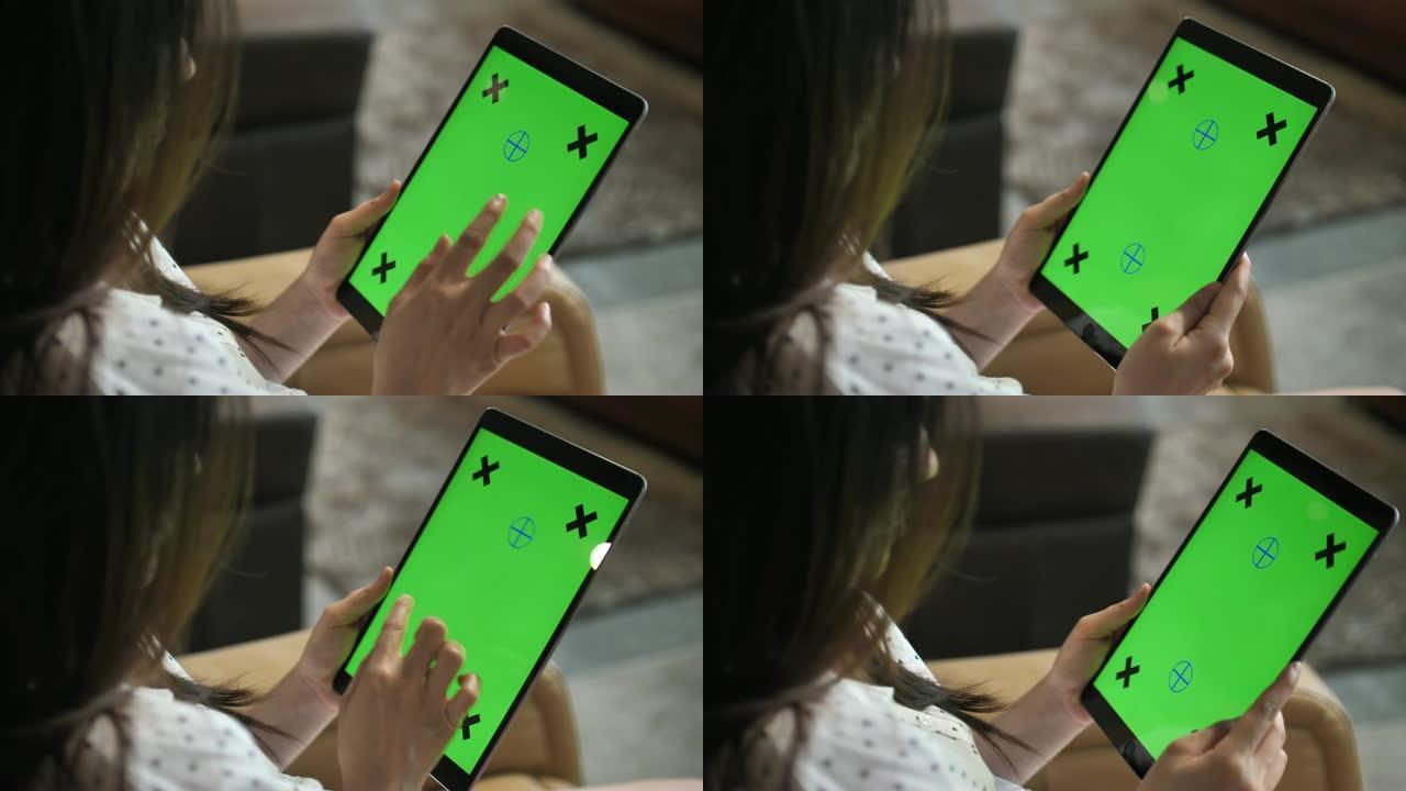 女人在设备屏幕上使用带有绿色屏幕的数字平板电脑