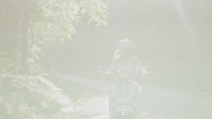 WS欣喜若狂的女人骑着踏板车穿过森林