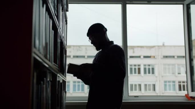 非裔美国人在大学图书馆的书架上看书