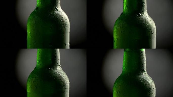 带冷凝液的冰啤酒。经典绿色瓶子。旋转倾斜拍摄。4K UHD