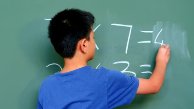 4k学校教室里用黑板解决数学问题的亚洲男生后视图