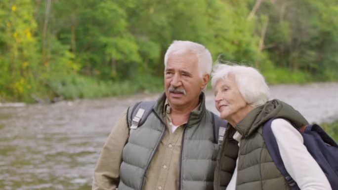 深情的老年夫妇在河边欣赏风景